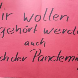 Protestplakat in Rot mit der Aufschrift in schwarz: Wir wollen gehört wreden auch nach der Pandemie!