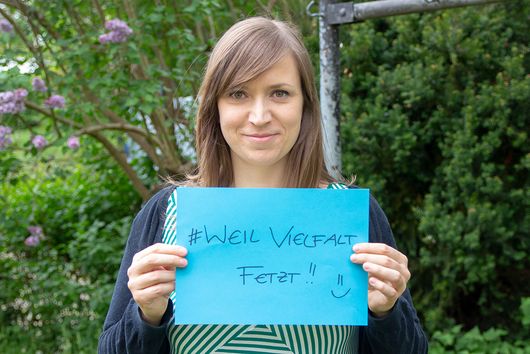 Kerstin Helm hält einen blauen Zettel mit den Worten "# Weil Vielfalt fetzt" vor sich