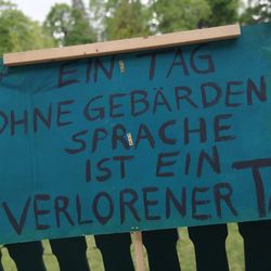 Protestplakat in blau: Ein Tag ohne Gebärdensprache ist ein verlorener Tag