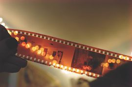 Filmrolle im Licht aufgerollt haltend
