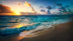Sonnenuntergang am Meeresstrand mit Wellen