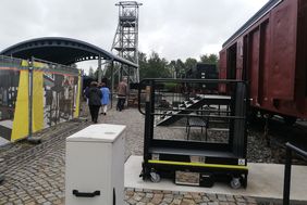 Das Außenareal des Museums: Rechts steht ein alter Güterzug, im Hintergrund sieht man einen Turm aus Metallstreben.