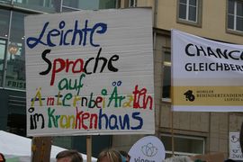 Plakat mit Aufschrift "Leichte Sprache auf Ämtern, im Krankenhaus und bei Ärzten