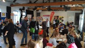 Blick auf die Messe mit Ständen und vielen Personen