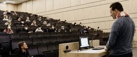 Professor hält Vorlesung in einem Hörsaal vor Studenten