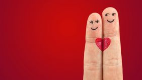 Zwei Finger dargestellt als Frau und Mann mit Gesichern und einem Herz