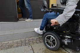 Rollstuhlfahrer steht vor Treppenstufe und Tür - kommt nicht hinein