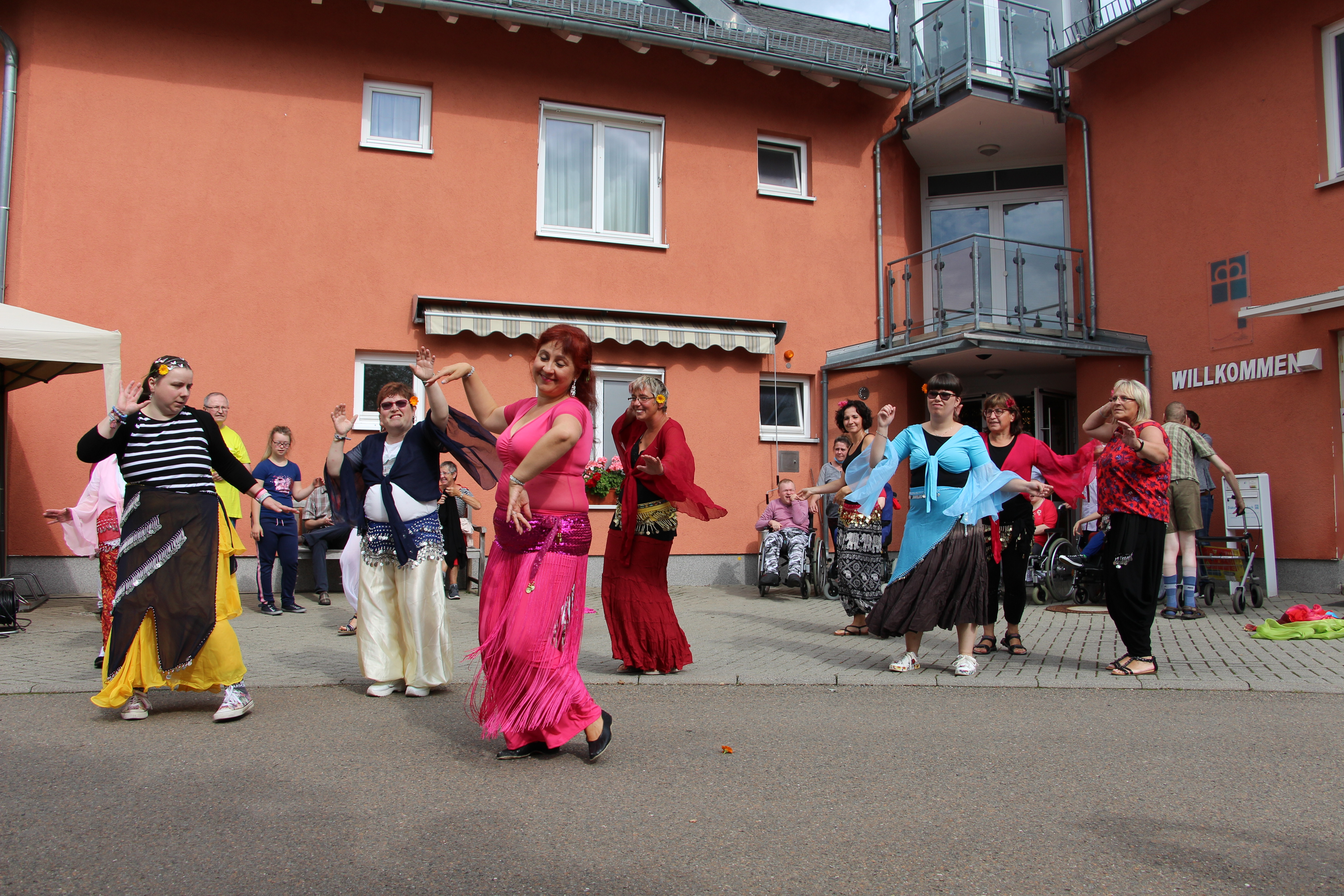 Mehrere Menschen tanzen vor dem "Haus Kirsche" der Diakonie in Auerbach